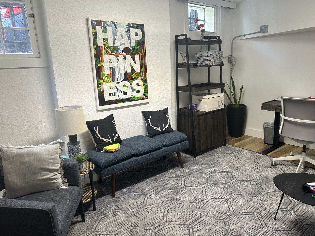 Capitol Hill office with blue couch seating, desk space, and wall art.